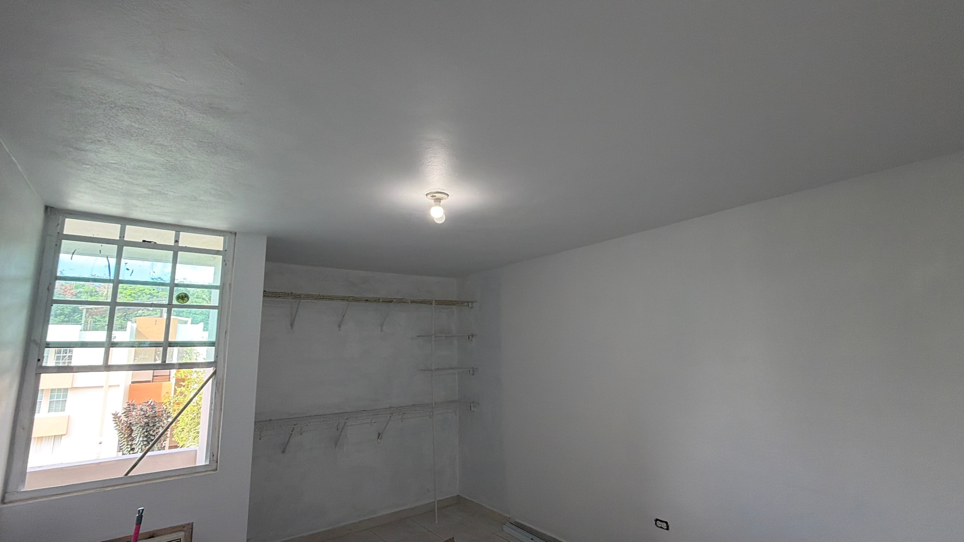 Cuarto terminado con techo y paredes reparadas y pintadas en blanco