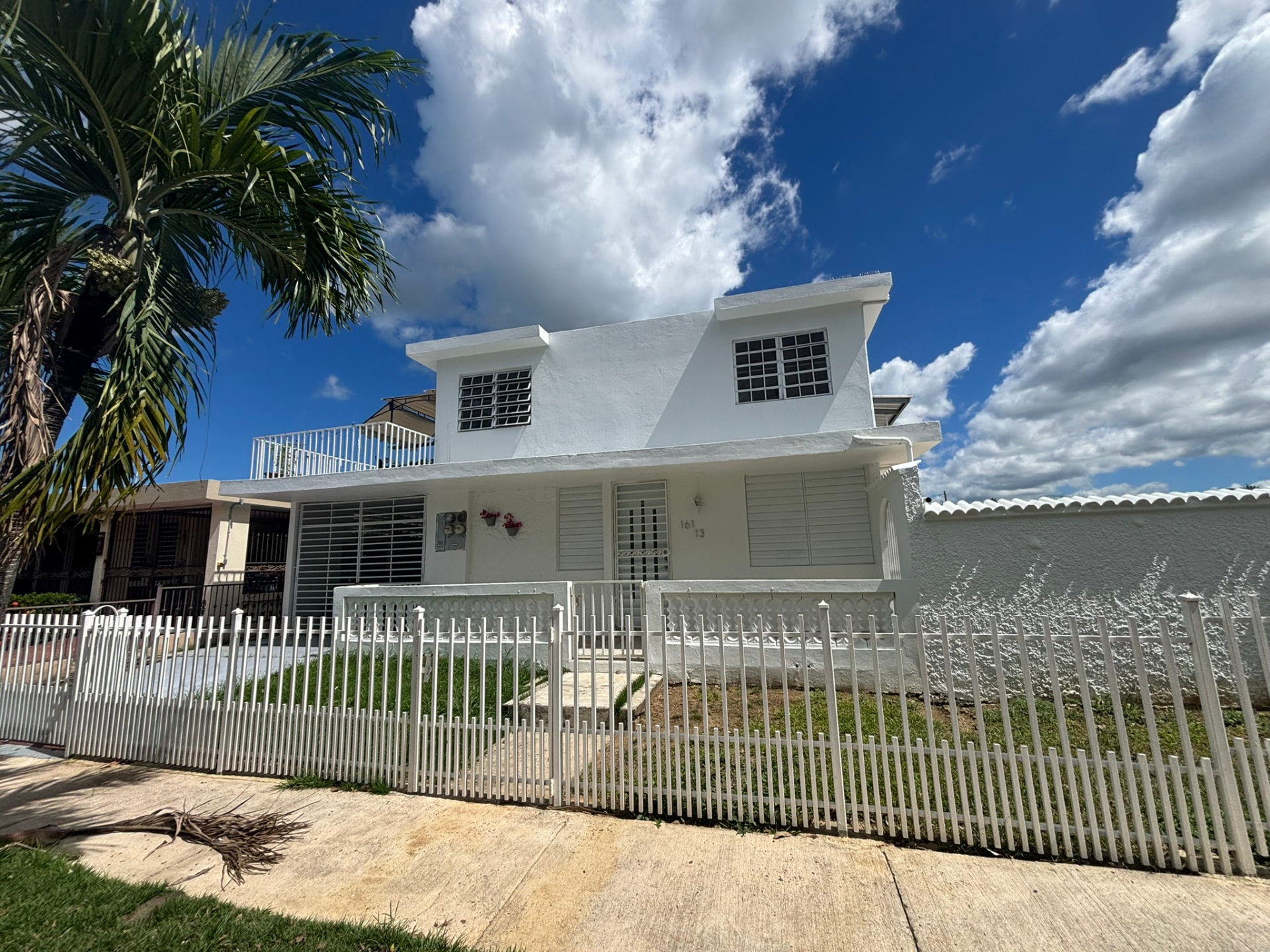 Residencia blanca terminada con verja y jardín en Puerto Rico