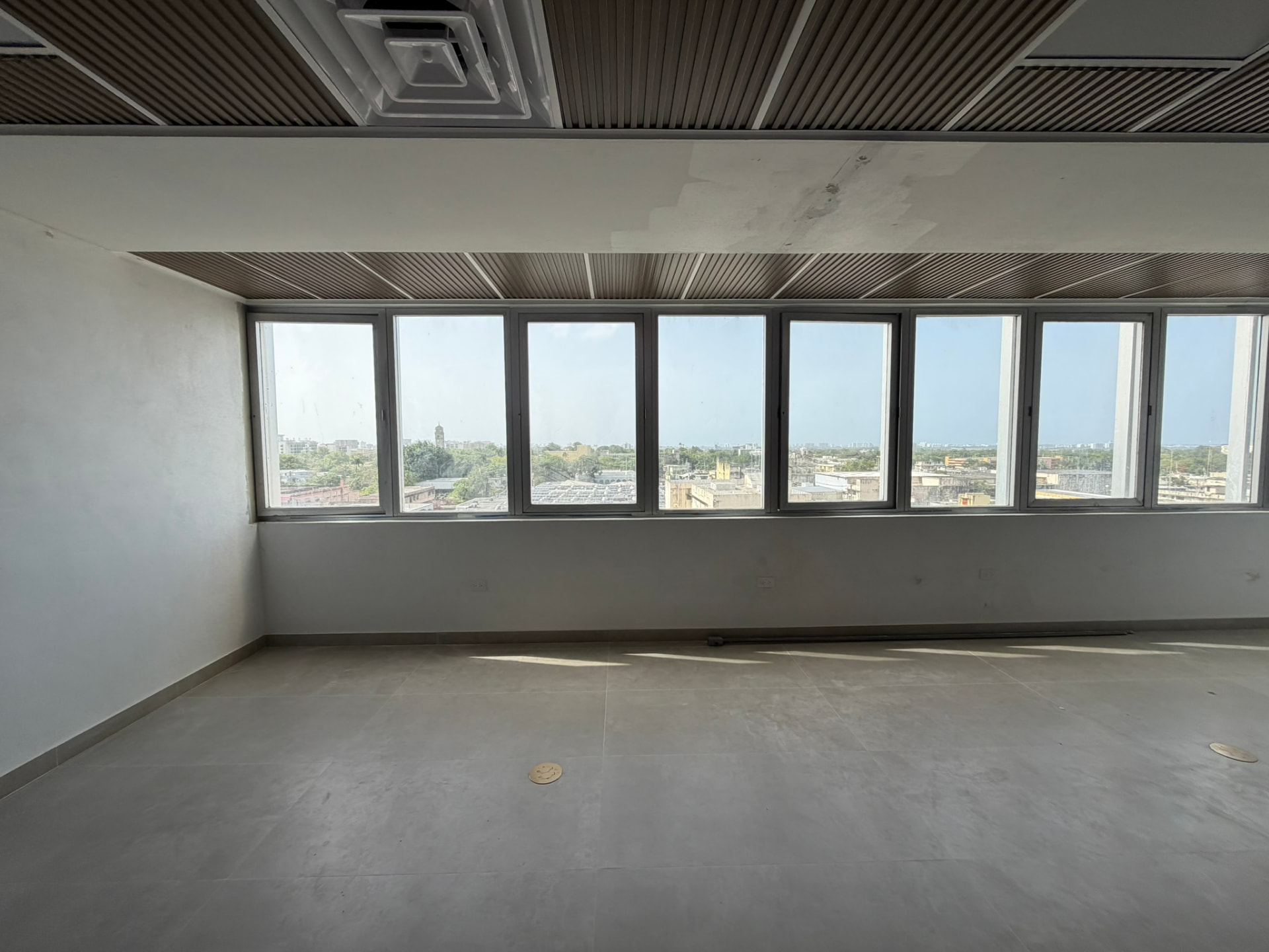 Oficina comercial terminada con losa de formato grande y vista a la ciudad
