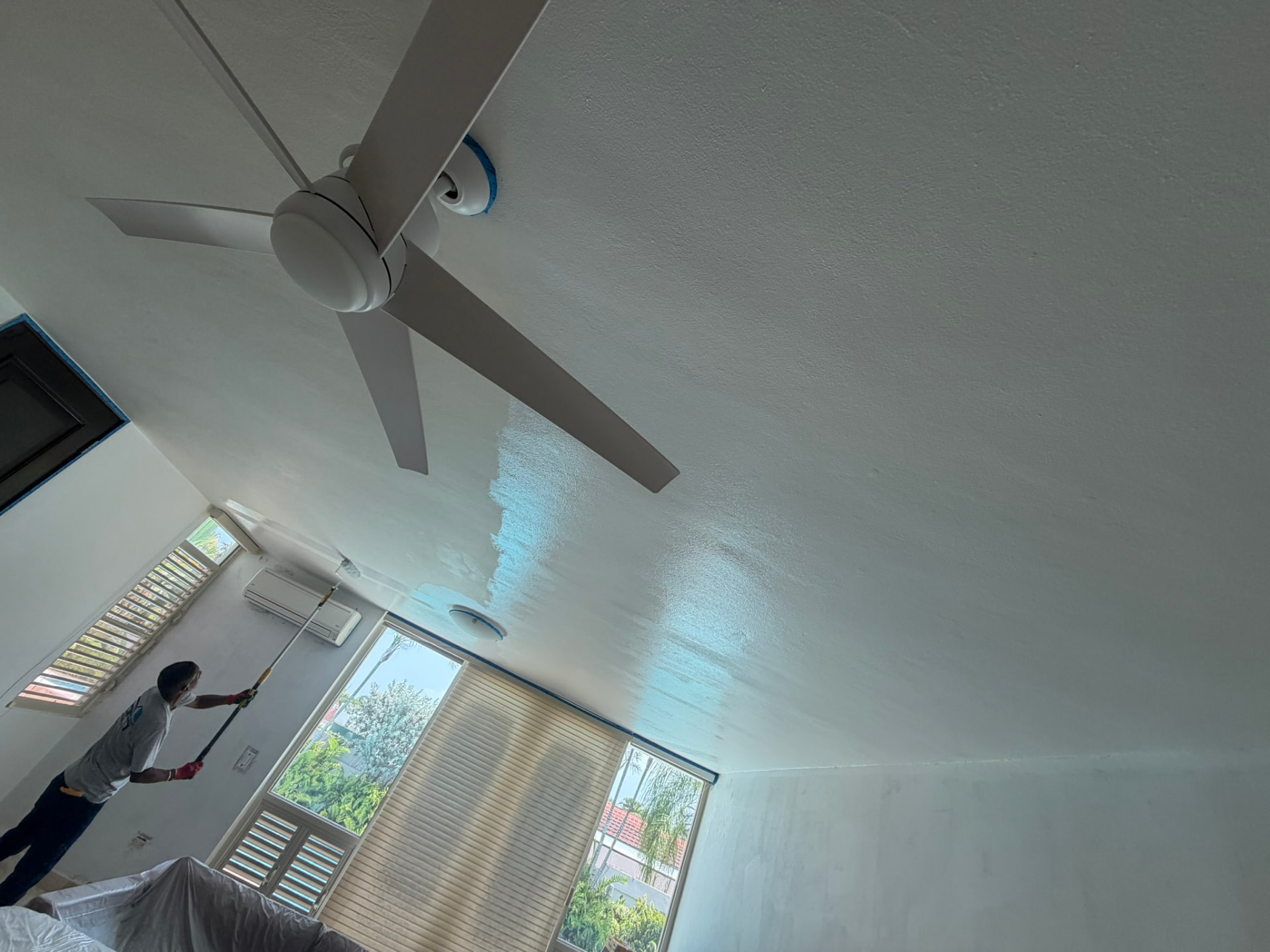 Aplicación de pintura fresca en techo interior con rodillo de extensión