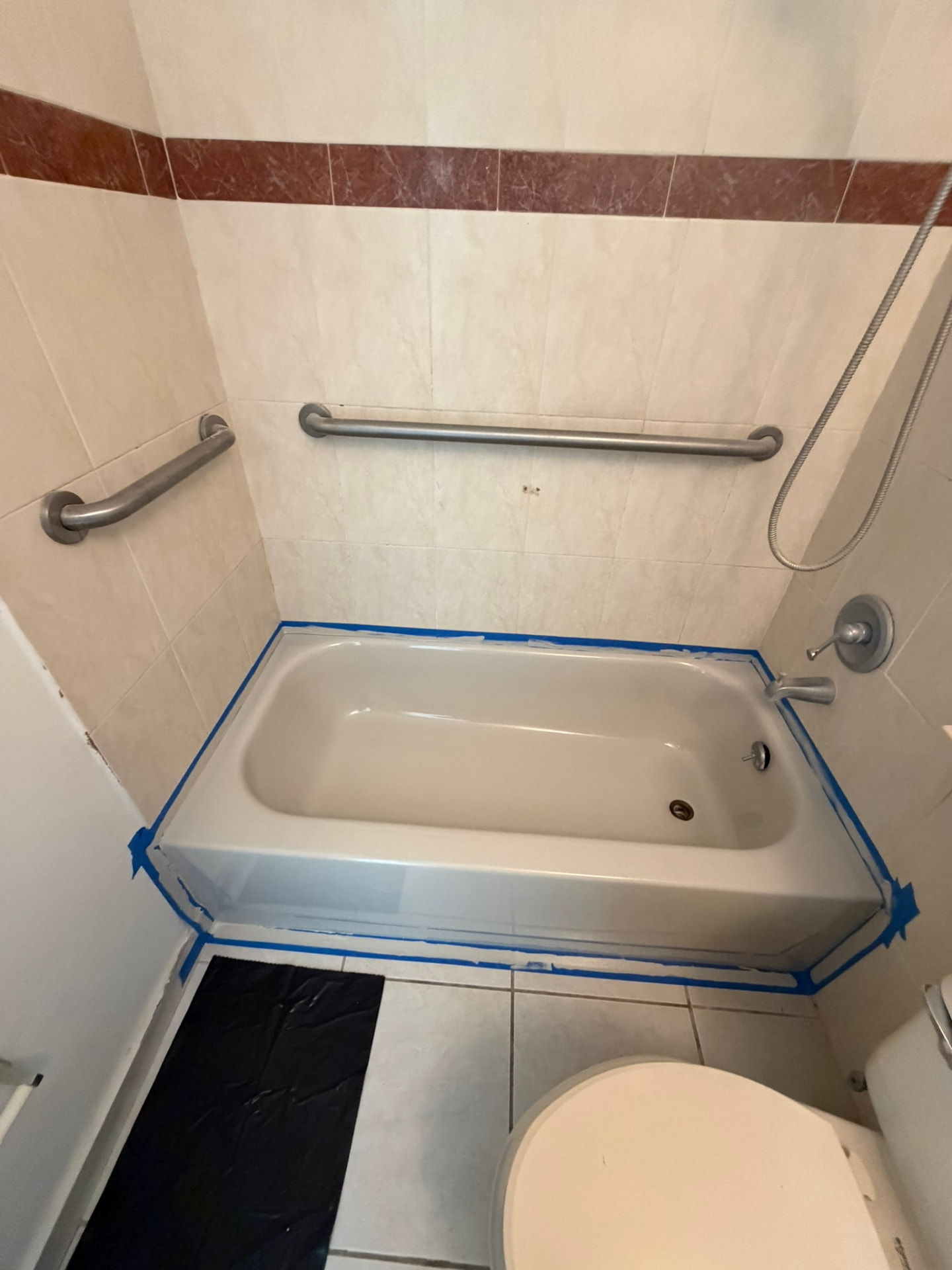 Bañera preparada con cinta azul antes del proceso de restauración