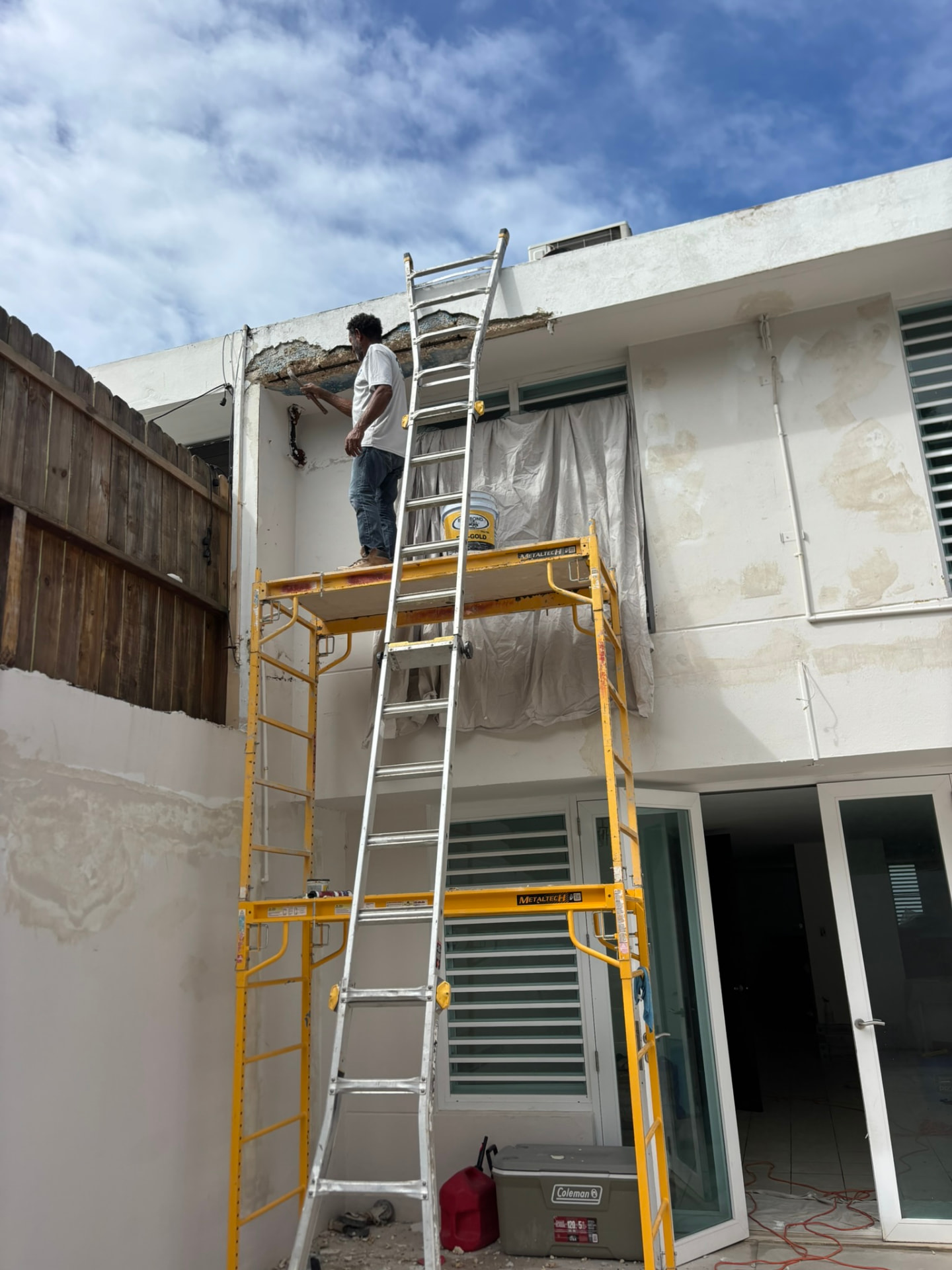Técnico de ROPO en andamio reparando alero afectado por filtración