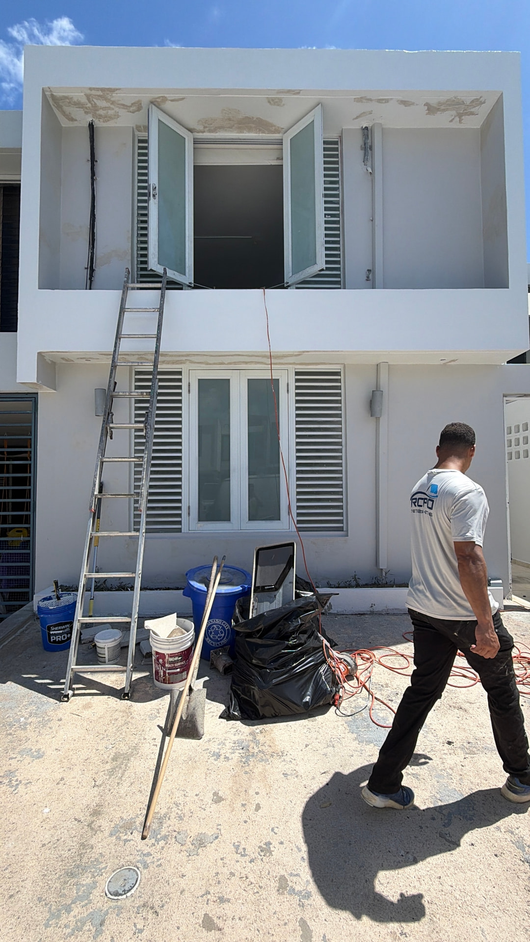 Técnico de ROPO trabajando en la fachada de una residencia de dos niveles