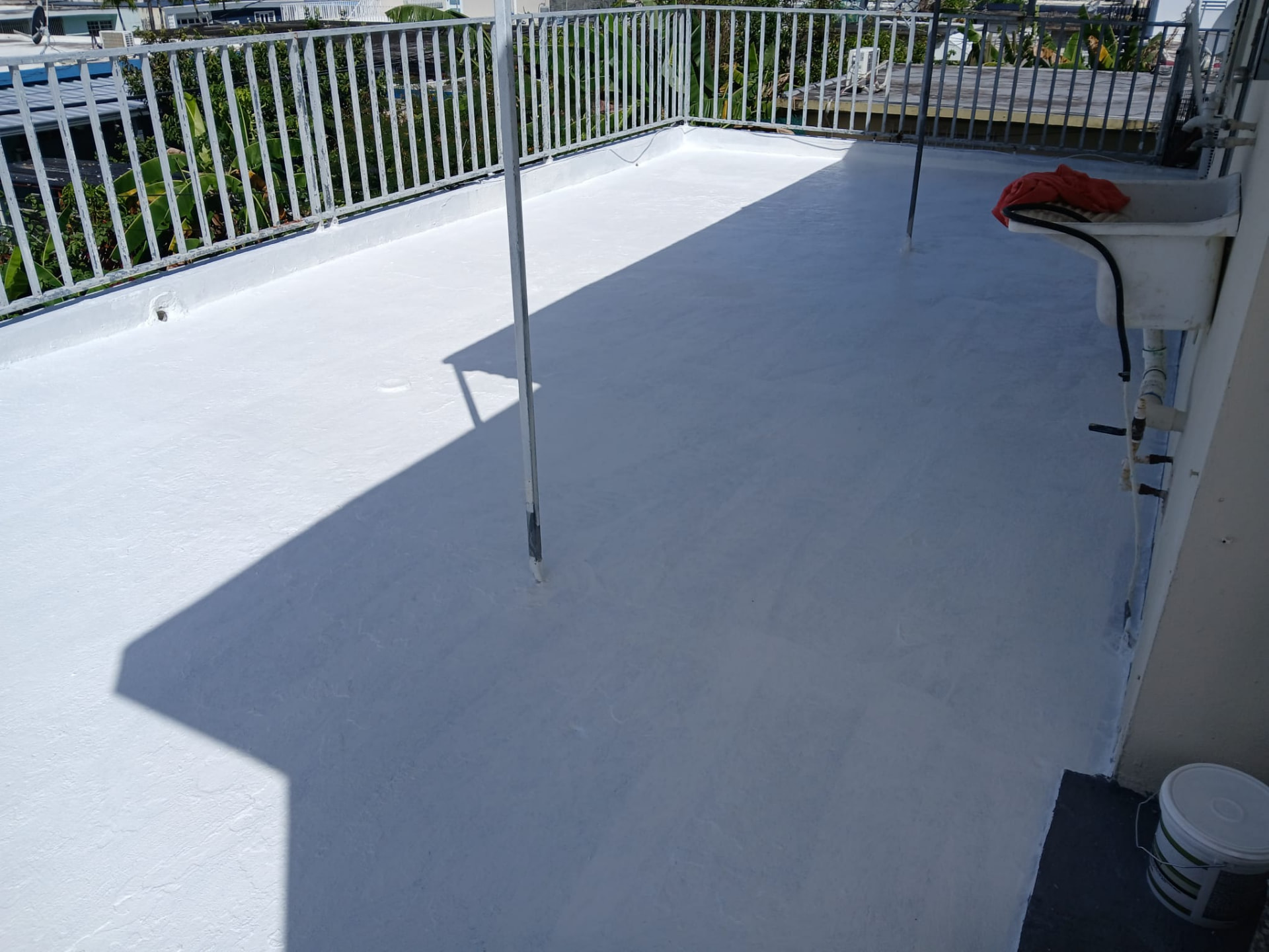Terraza sellada con acabado blanco elastomérico y barandas pintadas