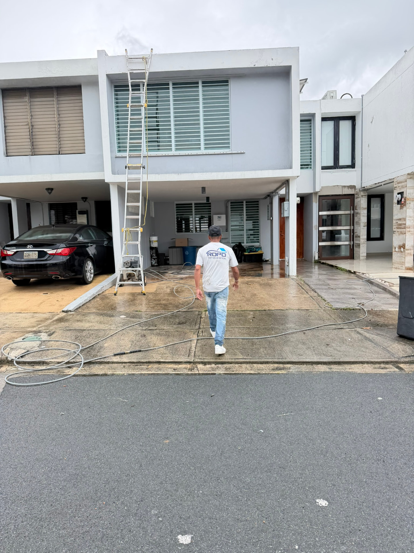 Técnico de ROPO frente a residencia de dos niveles durante lavado a presión